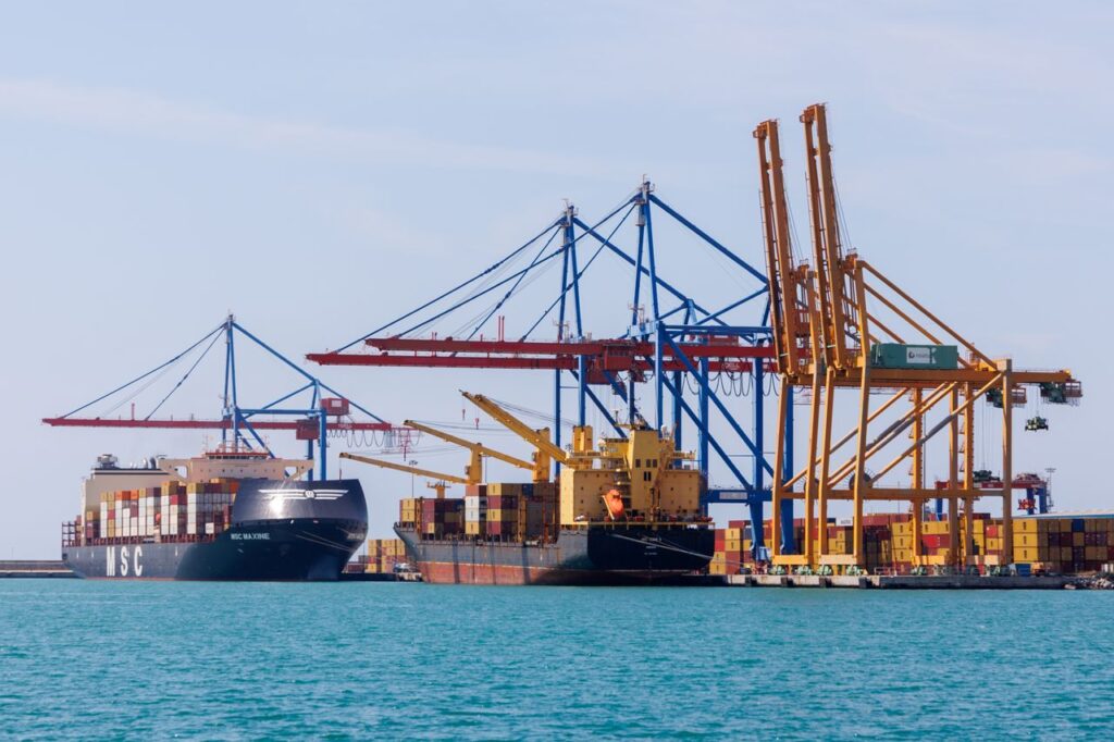 A vibrant view of Málaga's container port bustling with cranes and cargo ships during the day.